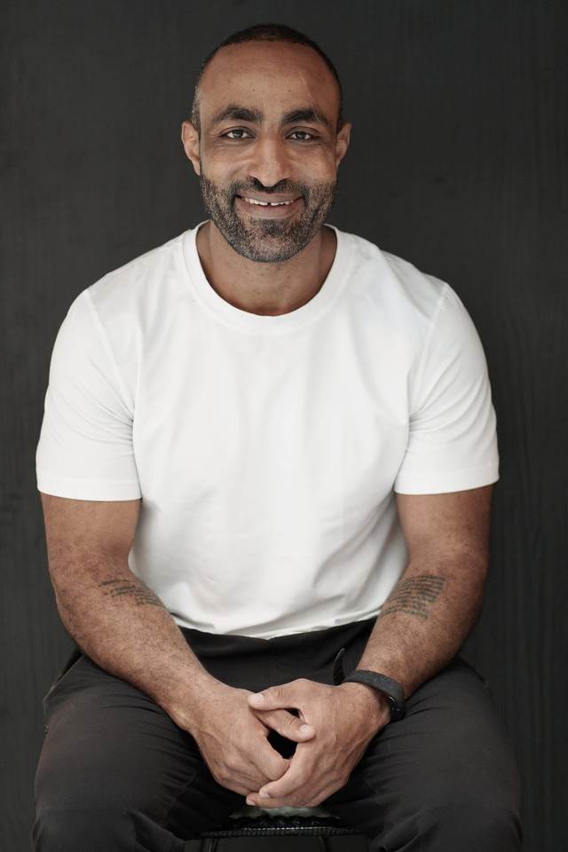 Founder of Yoncore Wellness, smiling, arms resting on his knees